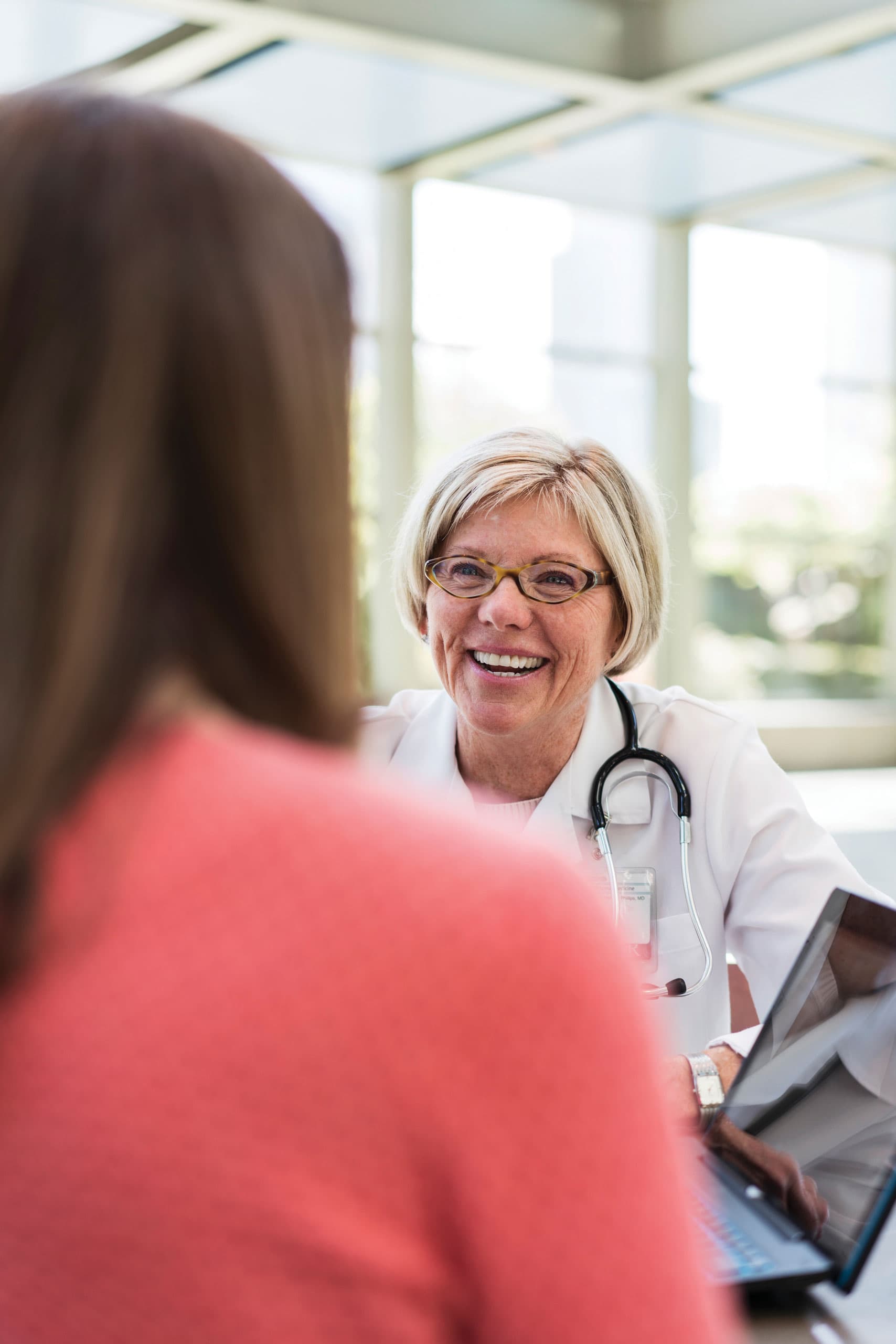 A nurse using a stethoscope on a patient
