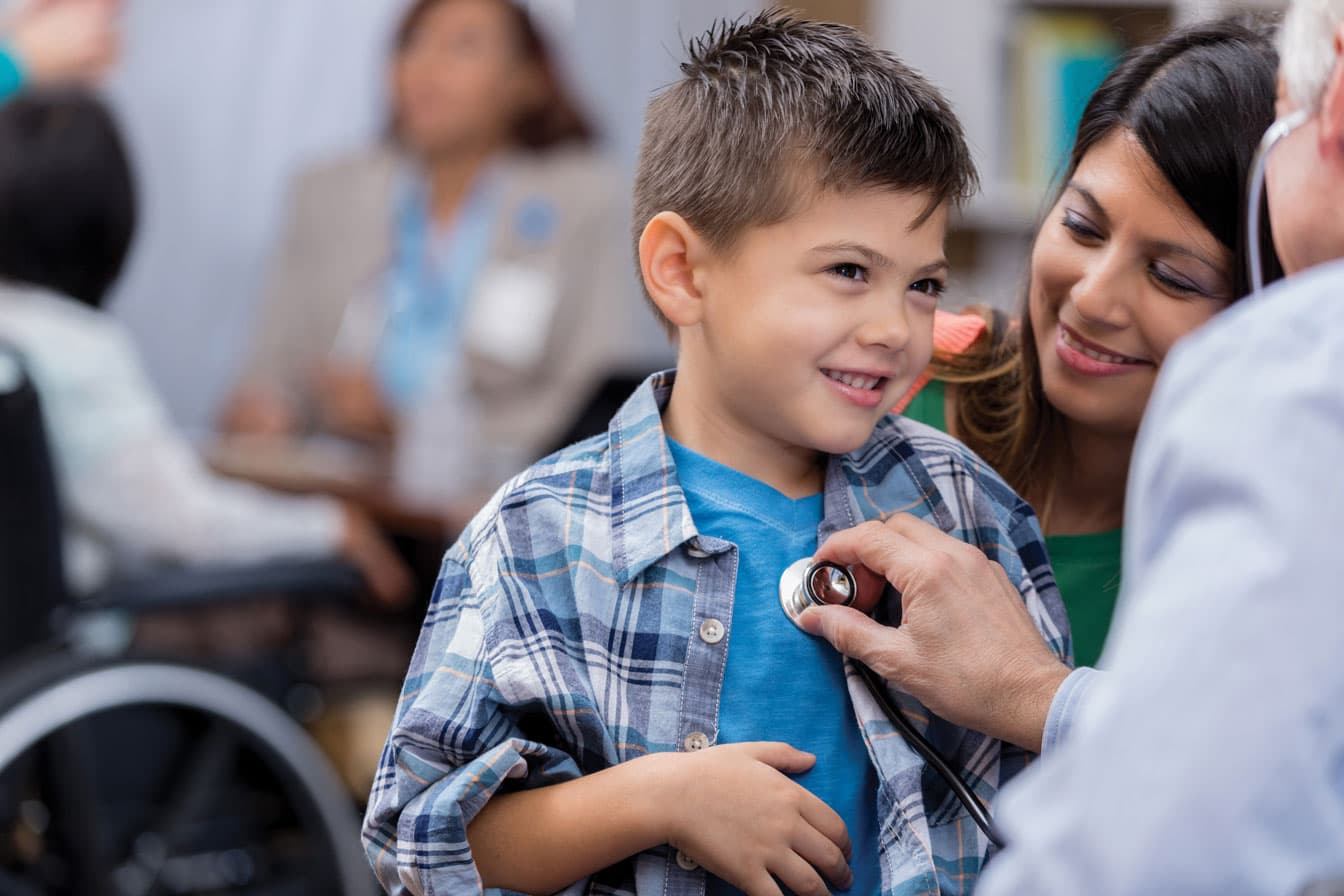Two medical employees working with a seated patient